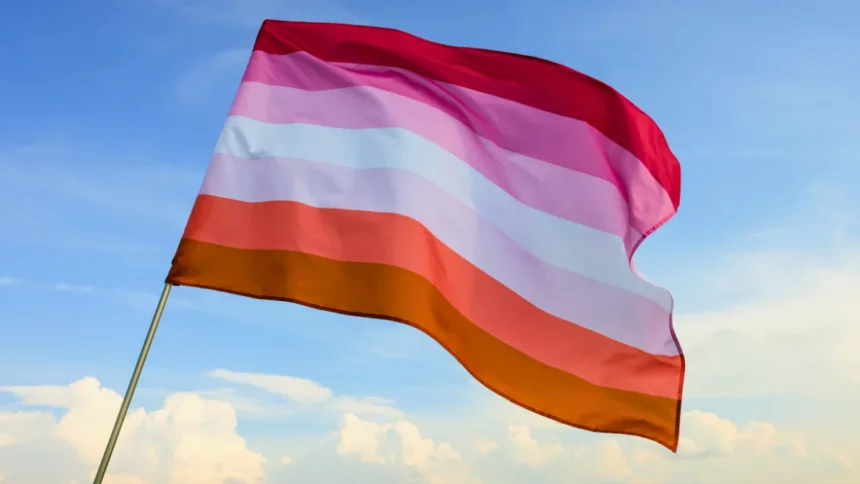 Sunset Lesbian Flag blowing in the wind, with a sky background