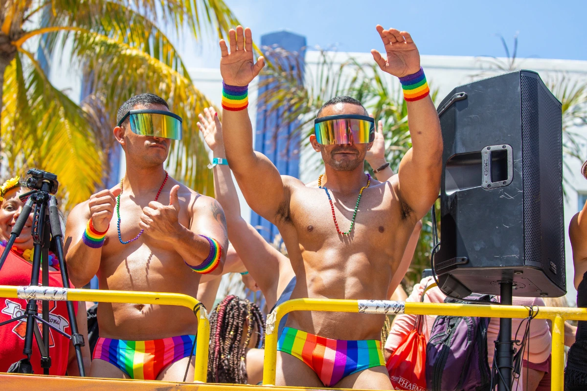 What Is a Gogo Boy? What Male Gogo Dancers Actually Do 13 Two gogo boys at a pride event on a float, wearing rainbow coloured clothing and accessories