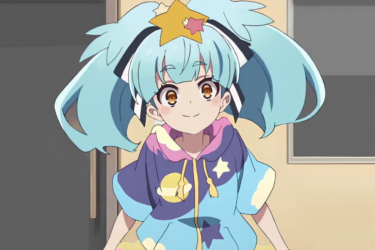 Lily Hoshikawa, in a loose-fitting blue and purple top, smiles as she looks towards the viewer