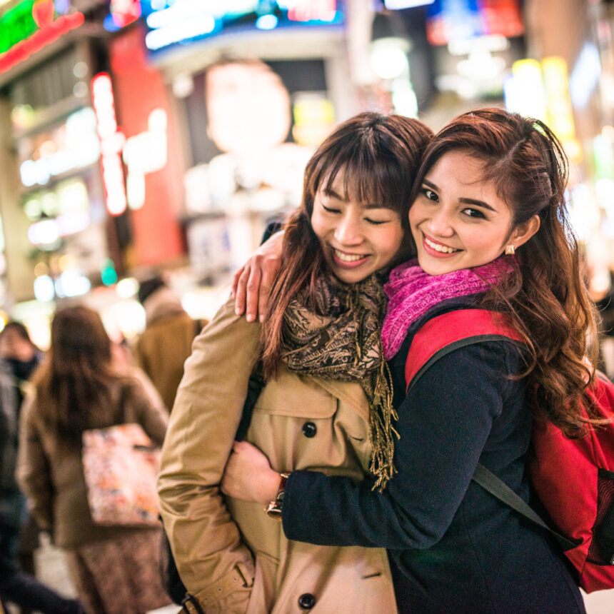 two women hugging in a bright street