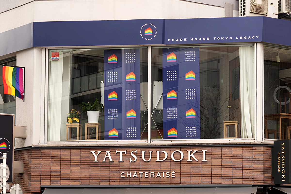 What Is It Like to Be Bisexual in Japan? 17 Exterior of Pride House Tokyo Legacy, with rainbow branding and Pride House Tokyo banners displayed in the windows above a Yatsudoki storefront.