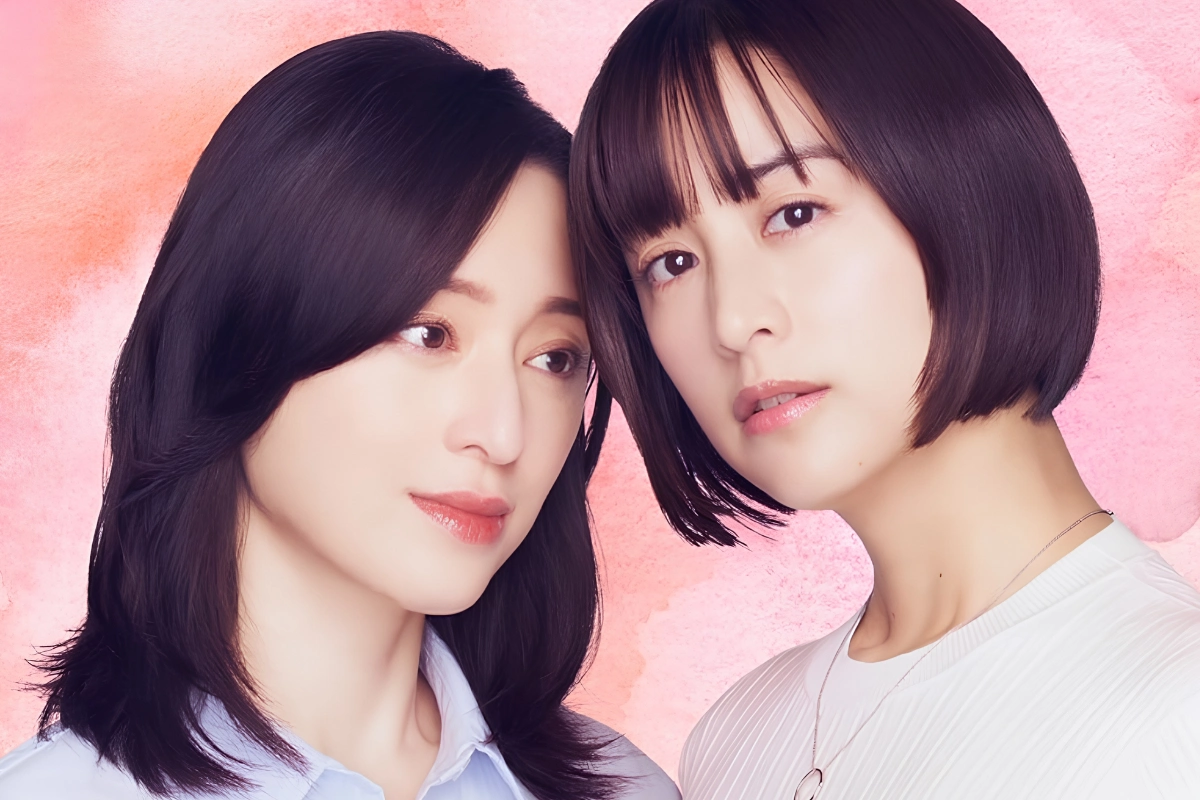 10 Best Japanese Lesbian Movies & Series to Watch 22 Two women pose closely together against a soft pink background, one with long dark hair and the other with a short bob haircut.