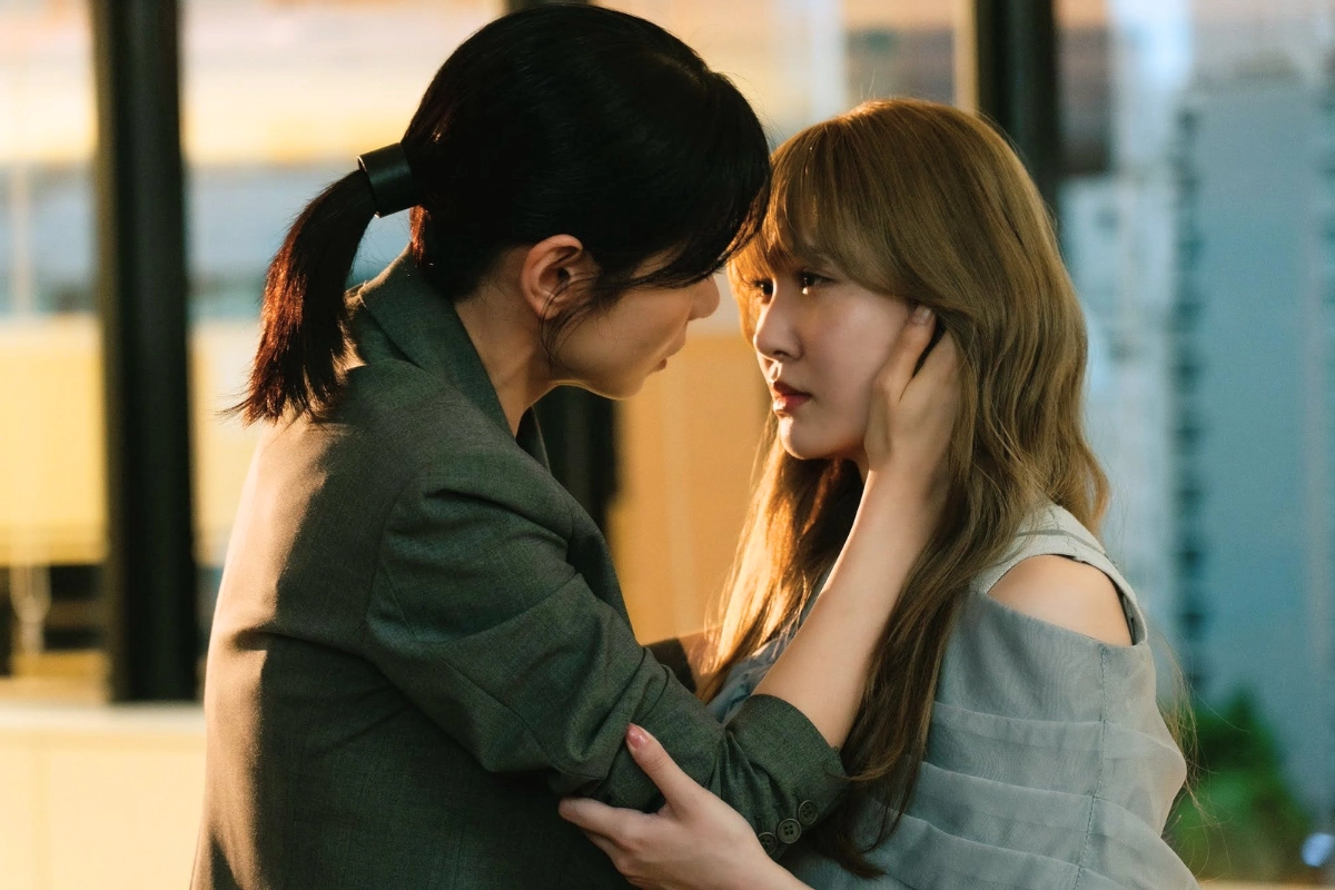 10 Best Japanese Lesbian Movies & Series to Watch 20 Two women stand closely together in warm light, one gently holding the other’s face as they look into each other’s eyes.