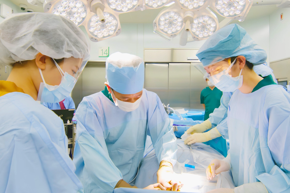 Getting Gender-Affirming Surgery in Japan: Providers, Costs and Preparation 13 Surgical team in masks and gowns performs a procedure beneath operating-room lights in a Japanese hospital.