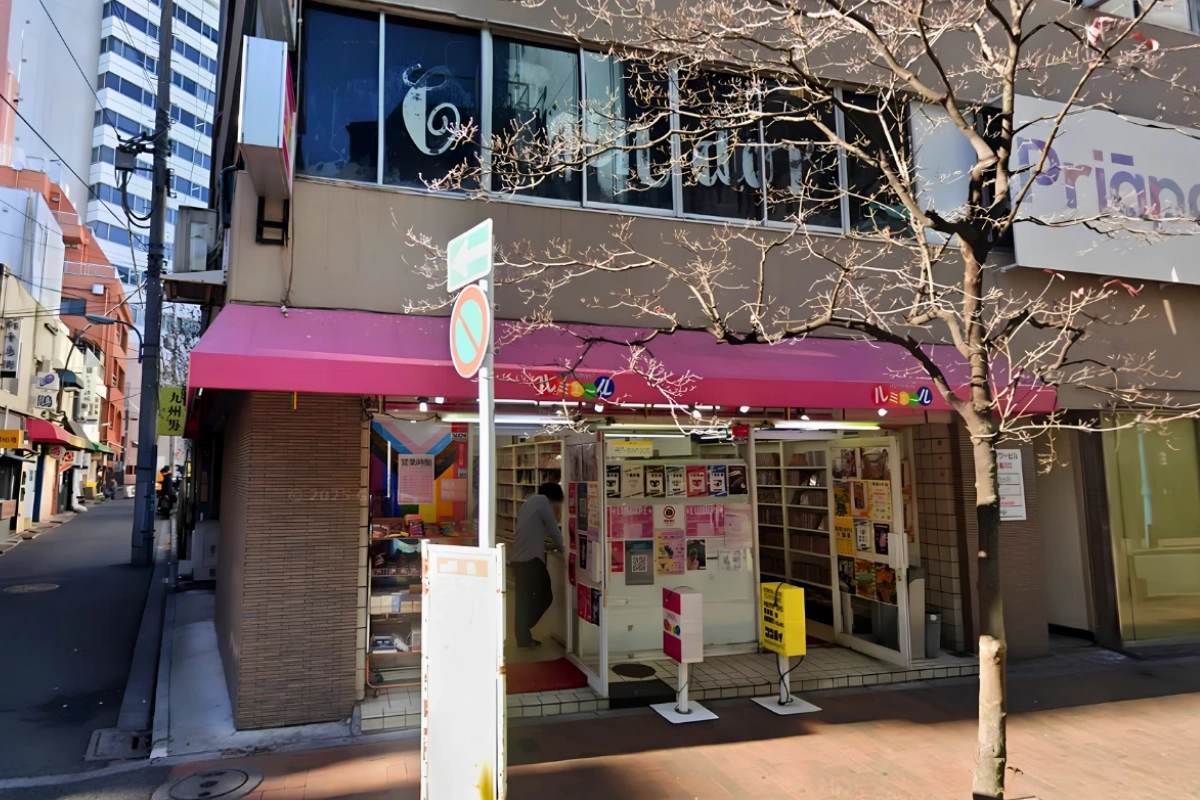 Where to Buy Yaoi/BL & Bara Manga in Japan 20 Exterior of Lumiere bookstore in Tokyo, with a pink awning and bookshelves visible through the entrance.
