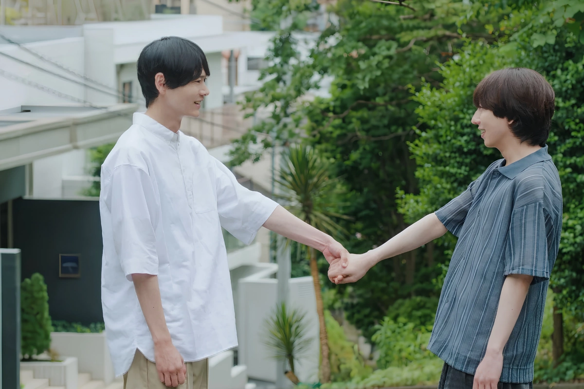Tachi and Neko Meaning: Japanese LGBTQ Slang Explained 16 Gay couple holding hands outside look into each others eyes while in mid-conversation.