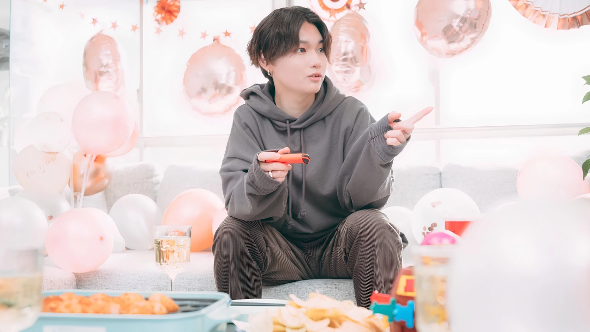 Rent a Boyfriend in Japan: How It Works, Costs, Rules, and Gay Options 16 Japanese boy in a party setting, drinking and eating party food while playing Nintendo Switch, while surrounded by balloons.