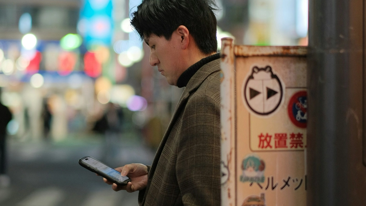 Hooking Up in Japan: A Guide for Gay and Bisexual Men 12 Japanese man checking his smartphone in a Tokyo nightlife district.