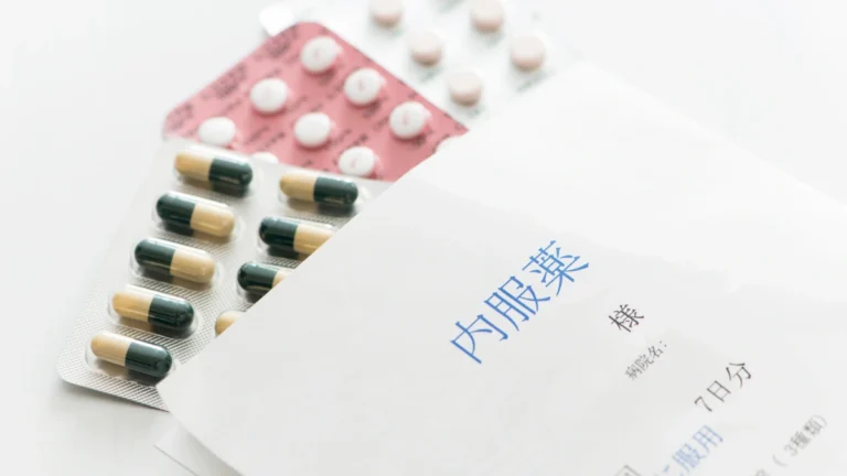 Hormone replacement therapy (HRT) medications, including prescription pills, next to a Japanese medication envelope.