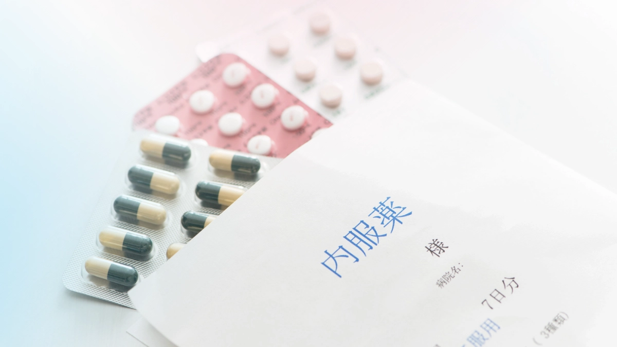 Hormone replacement therapy (HRT) medications, including prescription pills, next to a Japanese medication envelope.