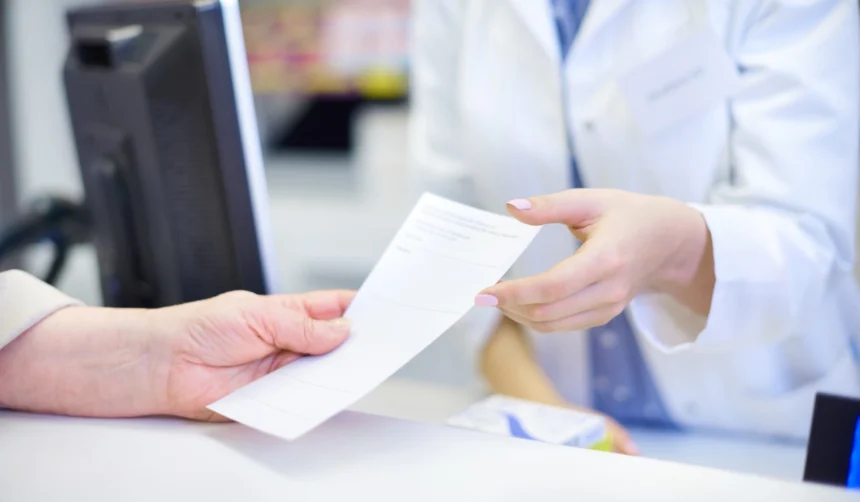 Handing a medical prescription to a pharmacist at a clinic counter to fill an HRT prescription in Japan.