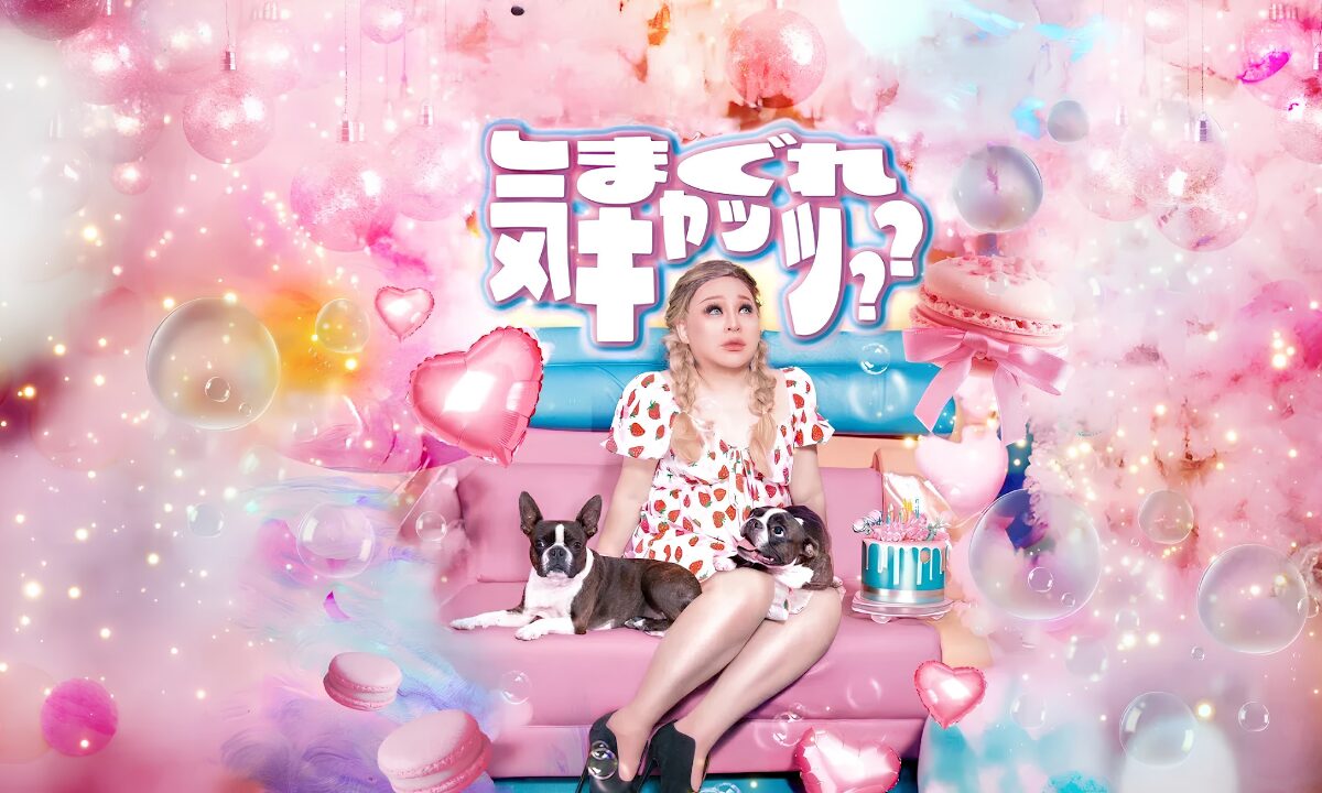 Against a bright floral background, a drag queen sits on a sofa with a small dog. Above and behind, "Kimagure Cats" is written in Japanese