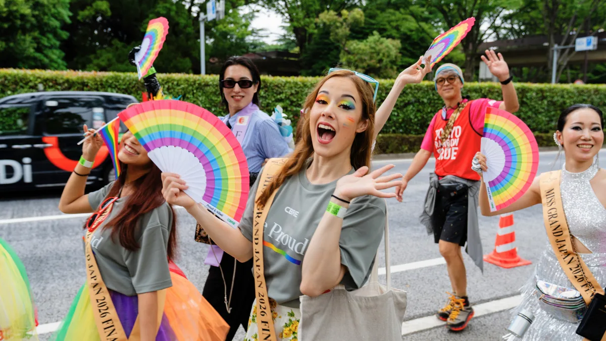 The History of Tokyo Pride: Protest, Party and Progress 17 Jubilant marchers holding rainbow colored folding fans wave to the camera at the Tokyo Pride 2026 Parade
