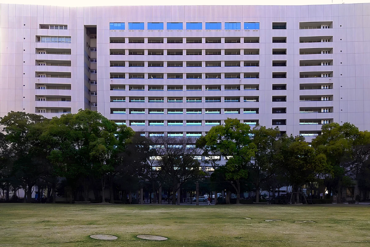 Trans Man Akira Aramaki Makes History Running for Mayor of Fukuoka 13 Exterior of Fukuoka City Hall in Tenjin, showing the large modern façade behind trees and an open lawn.
