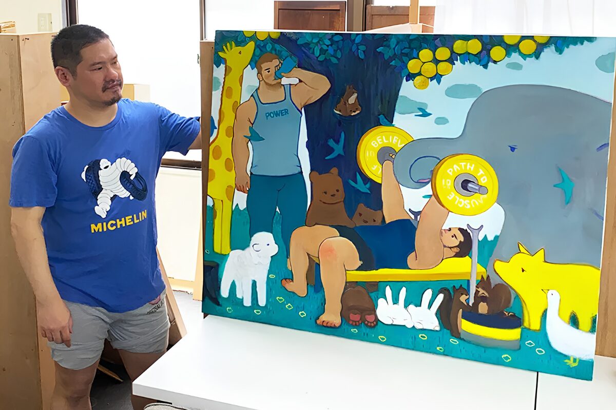 TORAJIRO’s “A Light That Never Goes Out”: Queer Masculinity, Vulnerability and Hope in Tokyo 10 TORAJIRO, in a blue t-shirt, stands by a painting of his in his studio