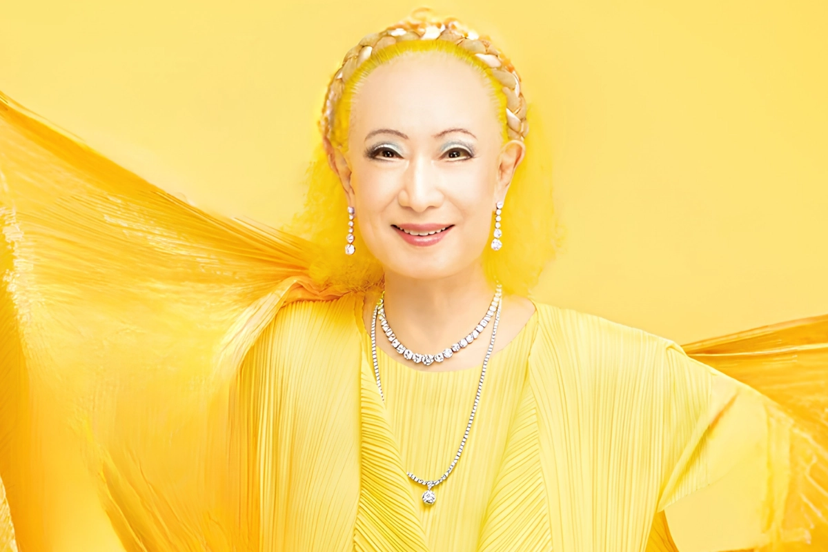 LGBTQ+ Japanese Celebrities to Know, From Pioneers to Today 18 Akihiro Miwa is seen posing and looking into the camera while wearing a yellow dress and silver jewellery