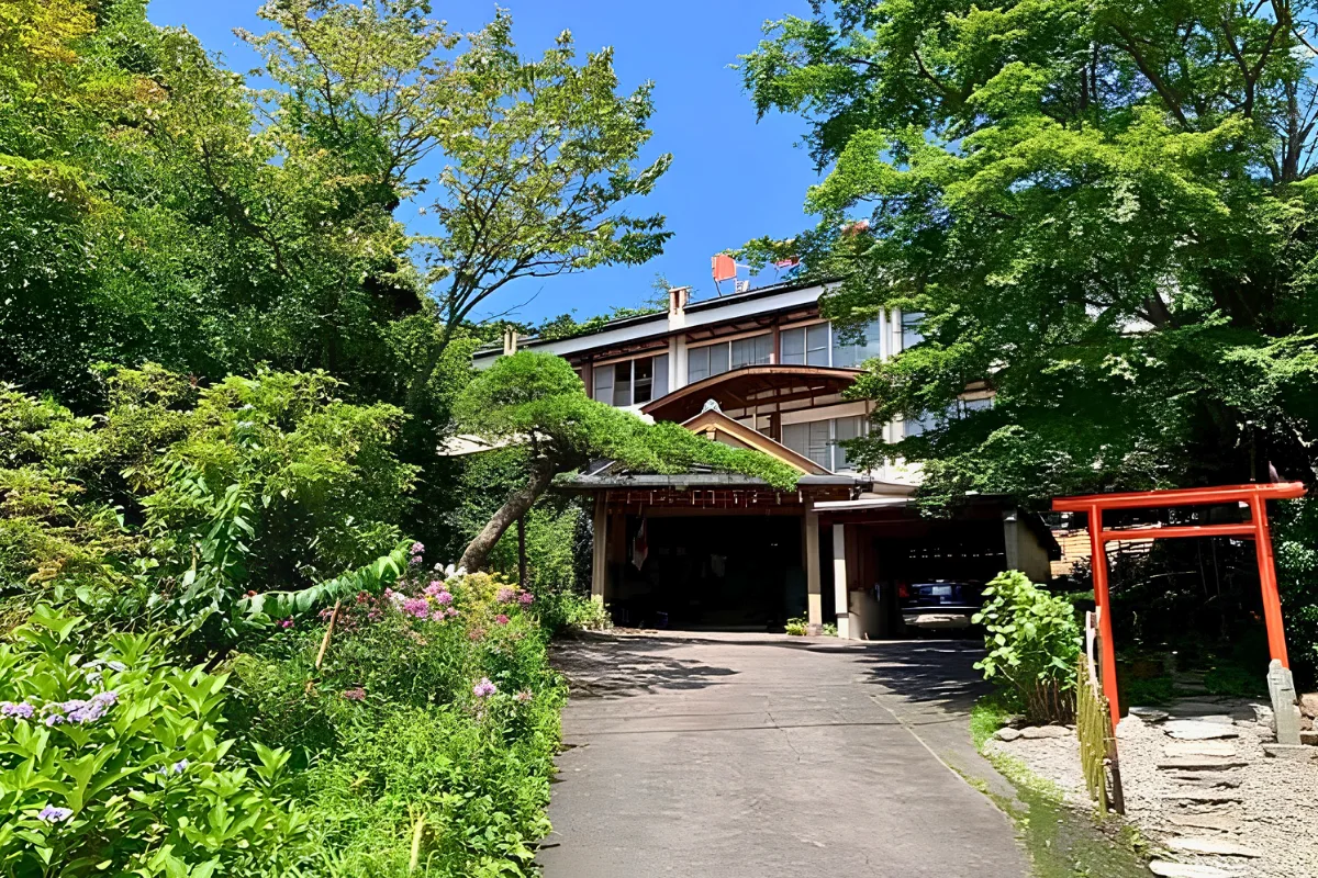 Gay-Friendly Ryokan in Japan: Evidence-Backed Stays for LGBTQ+ Travelers 12 Entrance to a traditional ryokan in Kusatsu surrounded by trees and garden greenery.