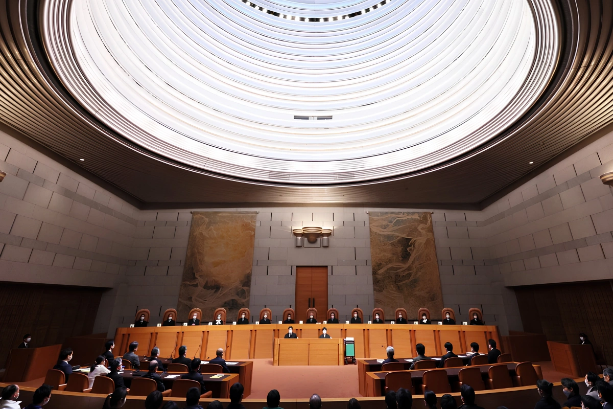 Grand Bench of the Japanese Supreme Court displayed with judges sat in position and spectators watching.