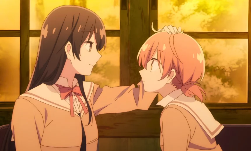 Two anime schoolgirls smile at each other as one gently rests a hand on the other’s head in warm sunset light.