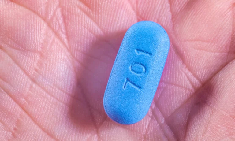 Close-up of a blue oval tablet marked “701” resting in the palm of a hand.