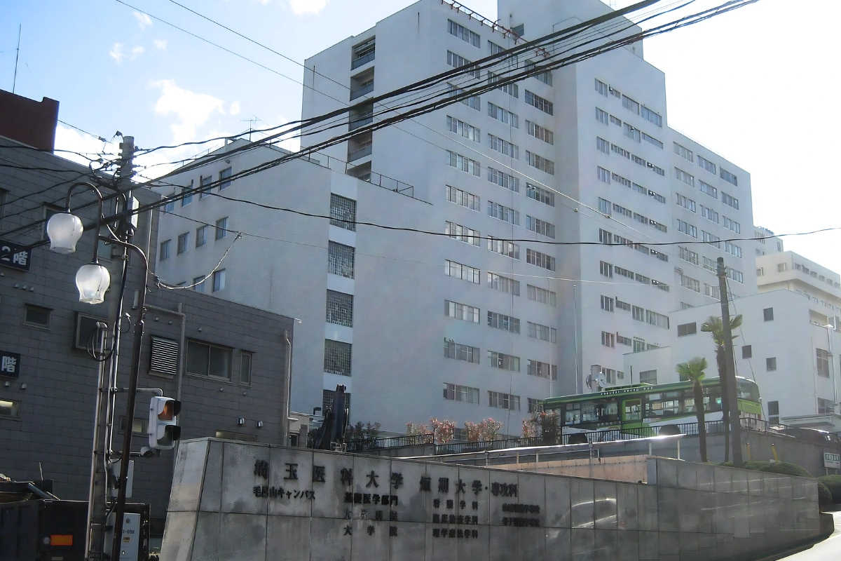 Saitama Medical University exterior taken from the road outside. The university sign is displayed at the front of the building. 